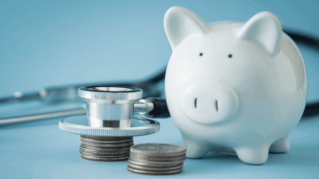 Weißes Sparschwein neben einem Stethoskop und gestapelten Münzen – Symbol für finanzielle Gesundheit, Vorsorge und verantwortungsbewussten Umgang mit Geld.